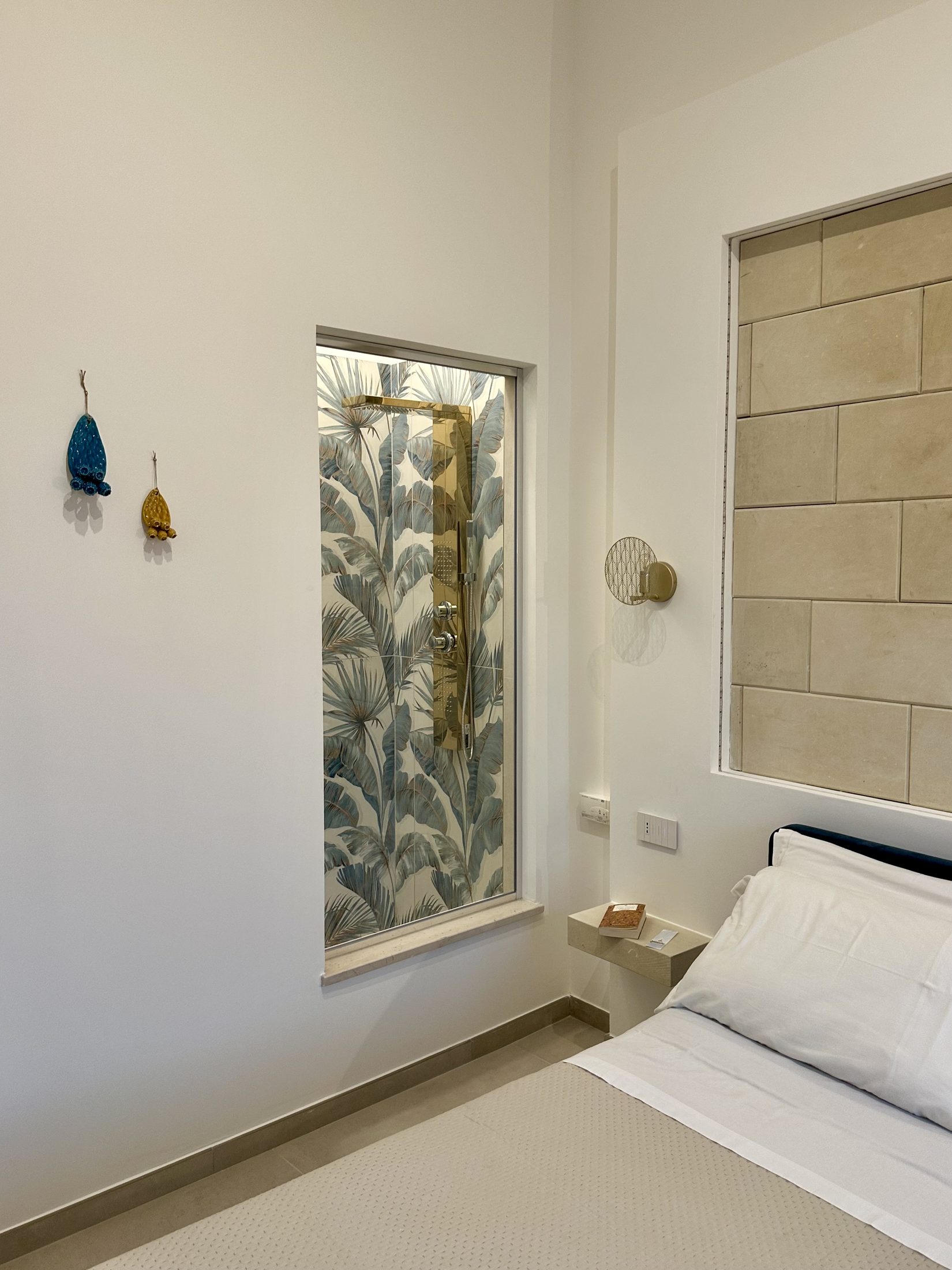 Doccia con maiolica tropicale e colonna idromassaggio dorata